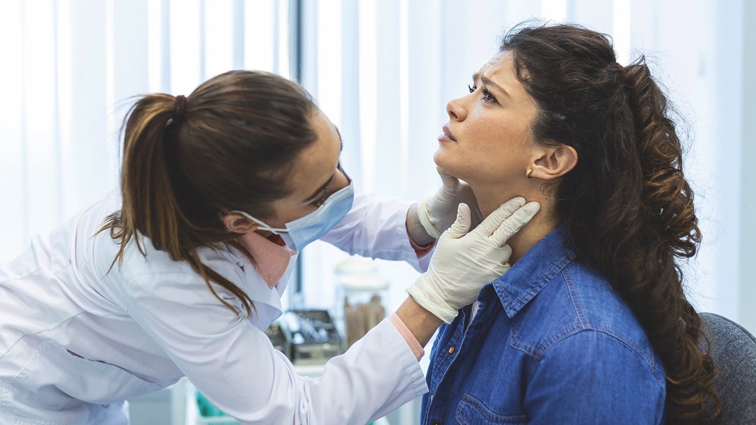 dental professional checking a patient for thyroid abnormalities