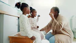 a mom brushing teeth with her two children a mom brushing teeth with her two children