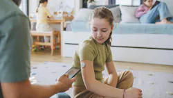 a little girl sitting on the floor beside a health-care professional a little girl sitting on the floor beside a health-care professional