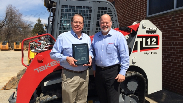 Takeuchi US president Clay Eubanks right presents Top Volume Dealer of the Year Award for 2014 to Folcomer Equipment president Dave Folcomer