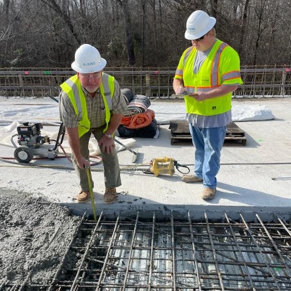 AtkinsR&eacute;alis Senior Bridge Inspector Jimmy Gragg measures depth during a deck pour alongside AtkinsR&eacute;alis Construction Inspector Mentee Kaleb Temples.