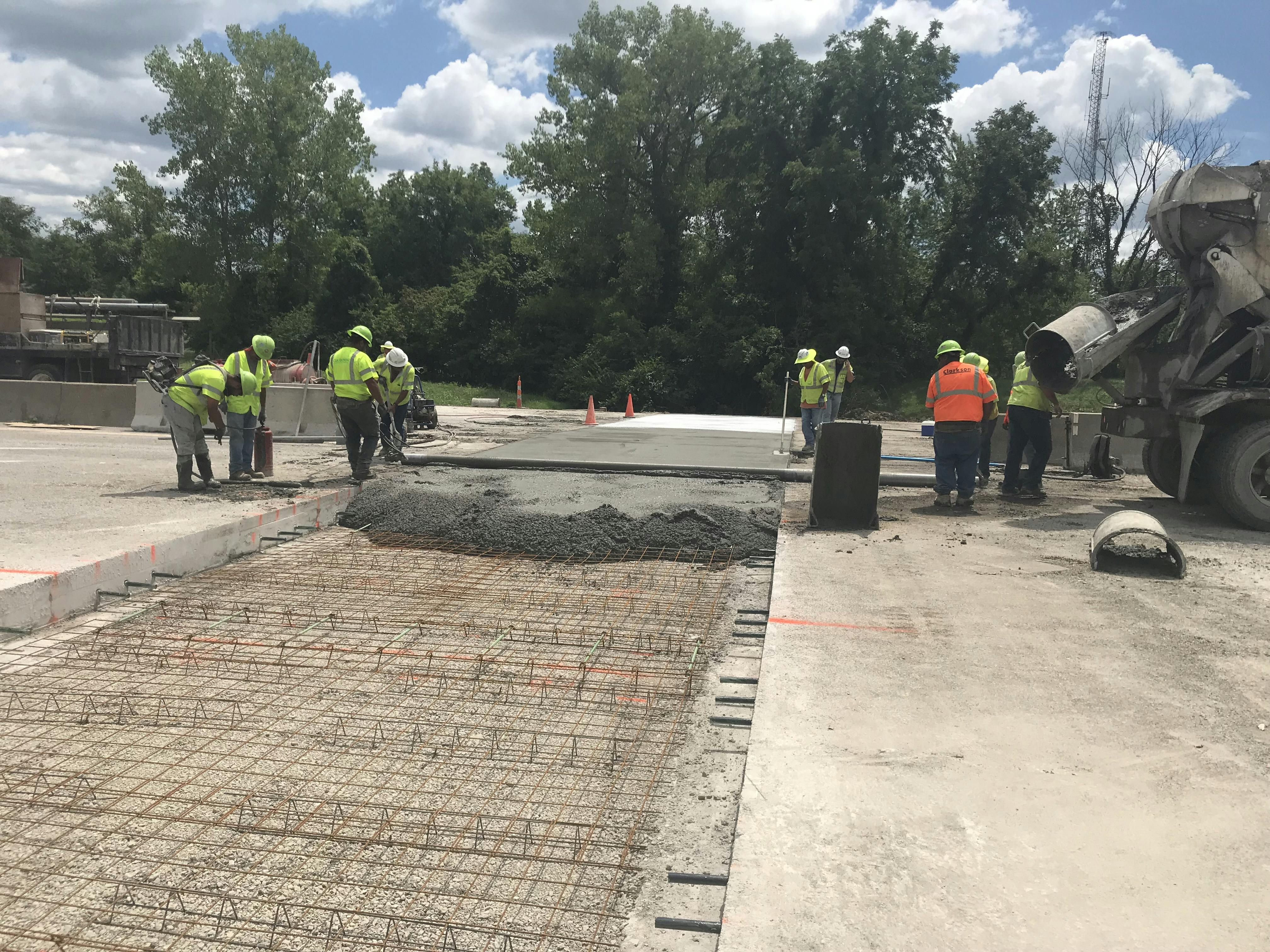 Construction workers are laying out concrete for a newly updated interchange in Kansas City, Kansas.