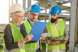Three civil engineers looking at plans on a job site. Three civil engineers looking at plans on a job site.