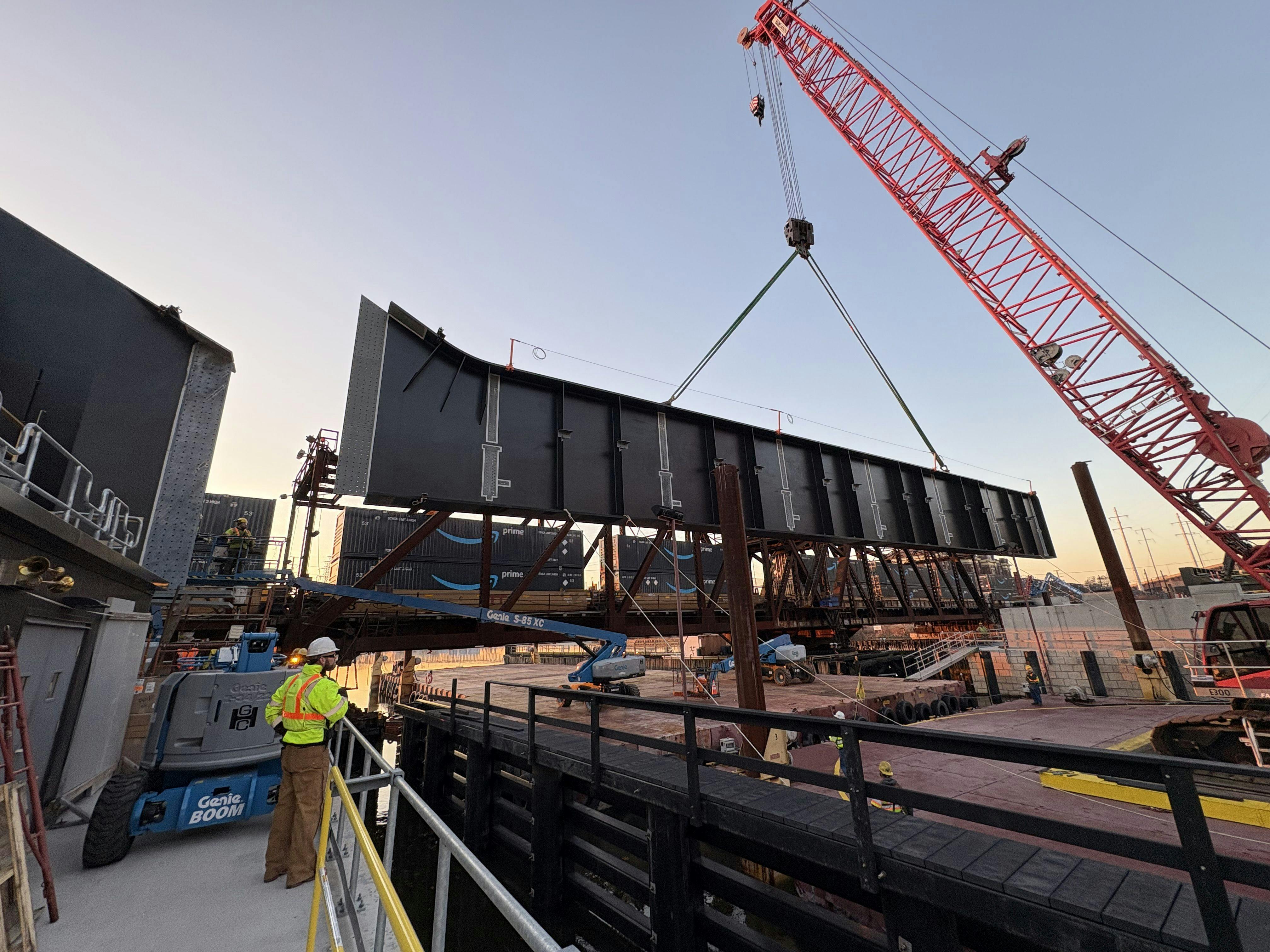Construction workers are using a crane to drop in the girders for a bridge replacement in New Jersey.