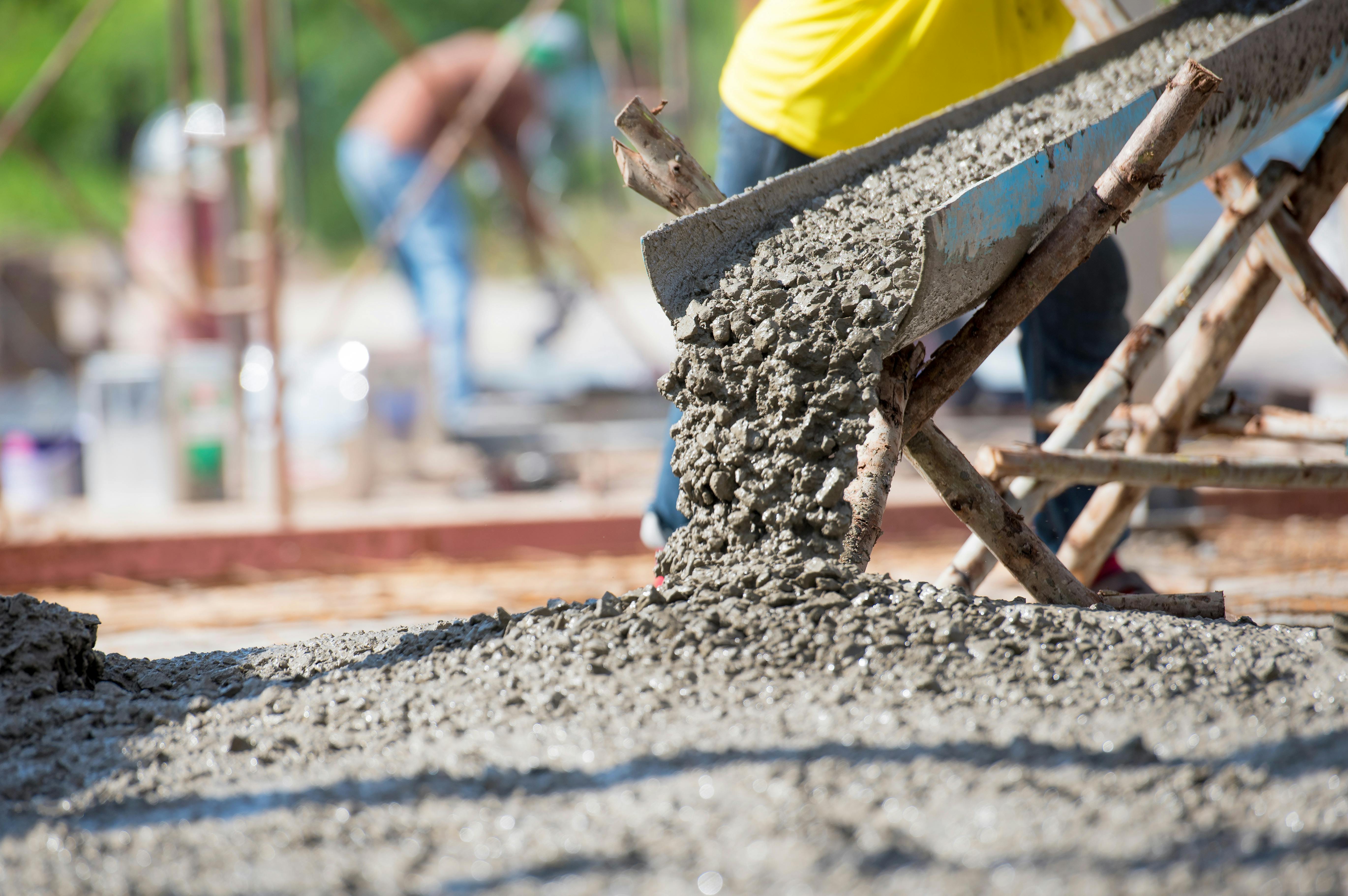 Concrete being poured onto a roadway.