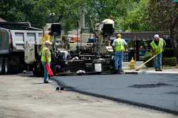 Workers completing repaving work on a roadway. Workers completing repaving work on a roadway.