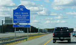 A sign on the side of a highway in Maryland welcoming drivers to the John F. Kennedy Memorial Highway. A sign on the side of a highway in Maryland welcoming drivers to the John F. Kennedy Memorial Highway.
