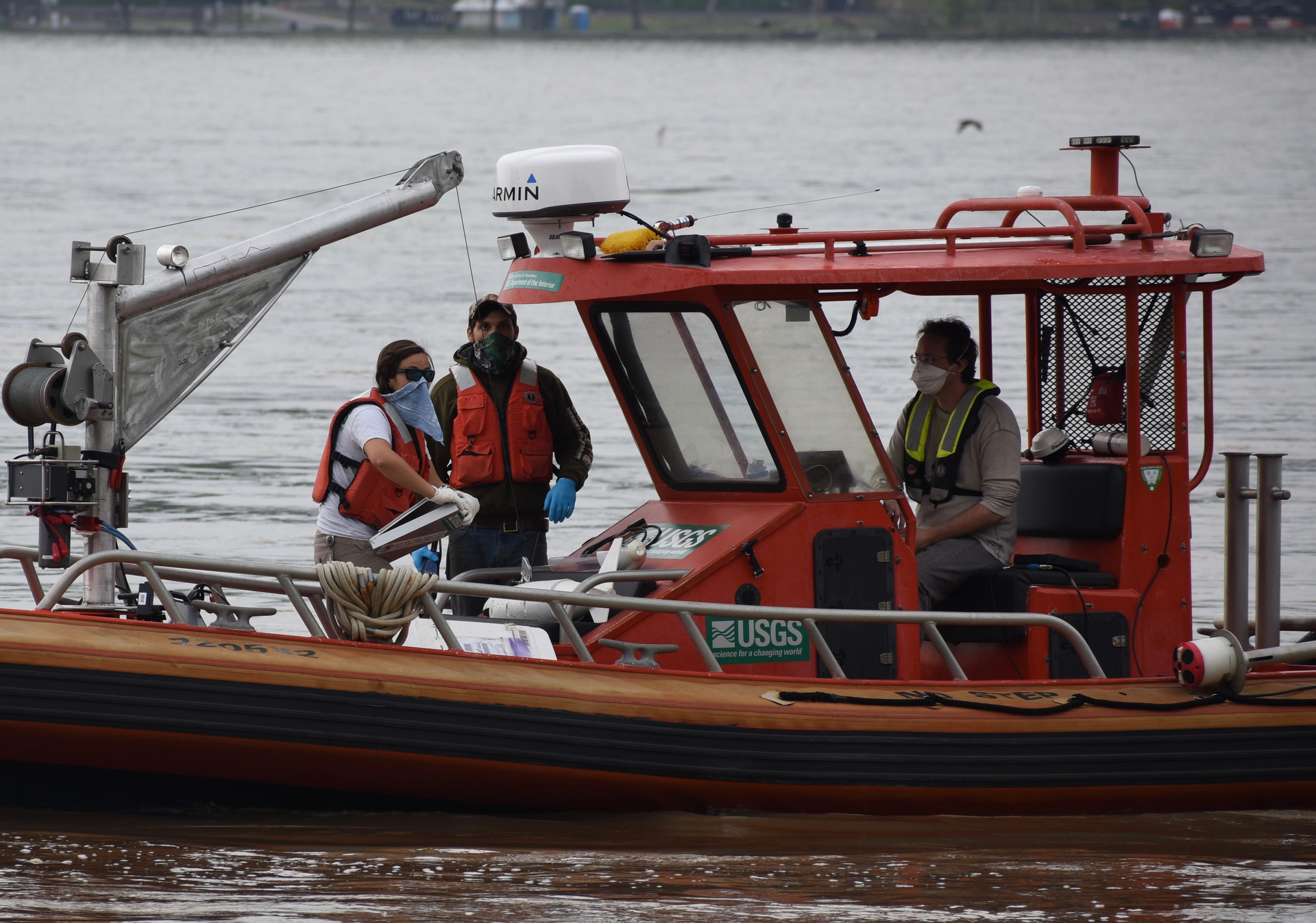 A USGS field team, including Pat Bowen, Kate Bowen, and John Trainor, uses specialized equipment to measure spring floodwaters at Chesapeake Bay's largest tributary, the Susquehanna River in Maryland. The team has an interesting strategy to deal with conflicts between sample-collection protocols and Covid-19 safe-distancing recommendations. Pat and Kate are married, so they can safely work together, while John maintains a safe distance at the helm.