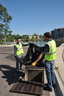 Workers install an Ultra-Drain Guard at a marina. Workers install an Ultra-Drain Guard at a marina.