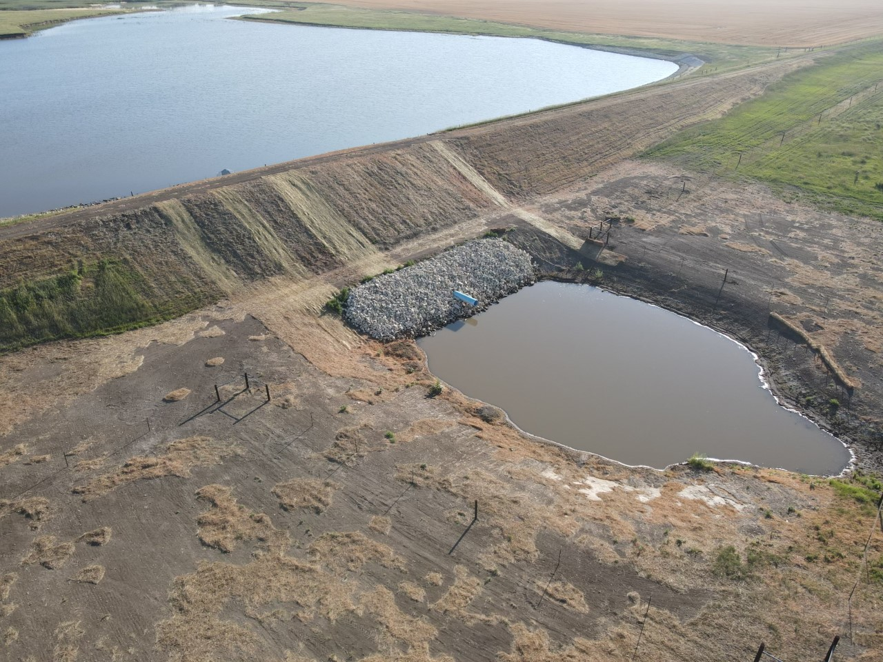 The team excavated the stilling basin and set rip rap along the bank and then set a new pipe riser for the new overflow pipe.