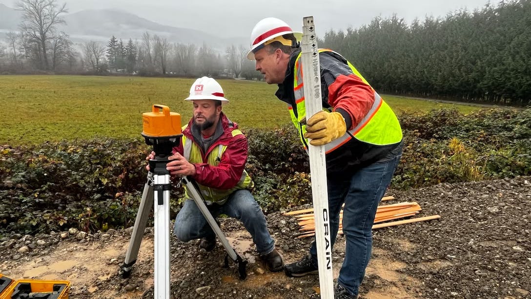 USACE flood team members Jeff Wood and Stephen Green work at a levee near Hamilton, Washington, December 5, 2023.