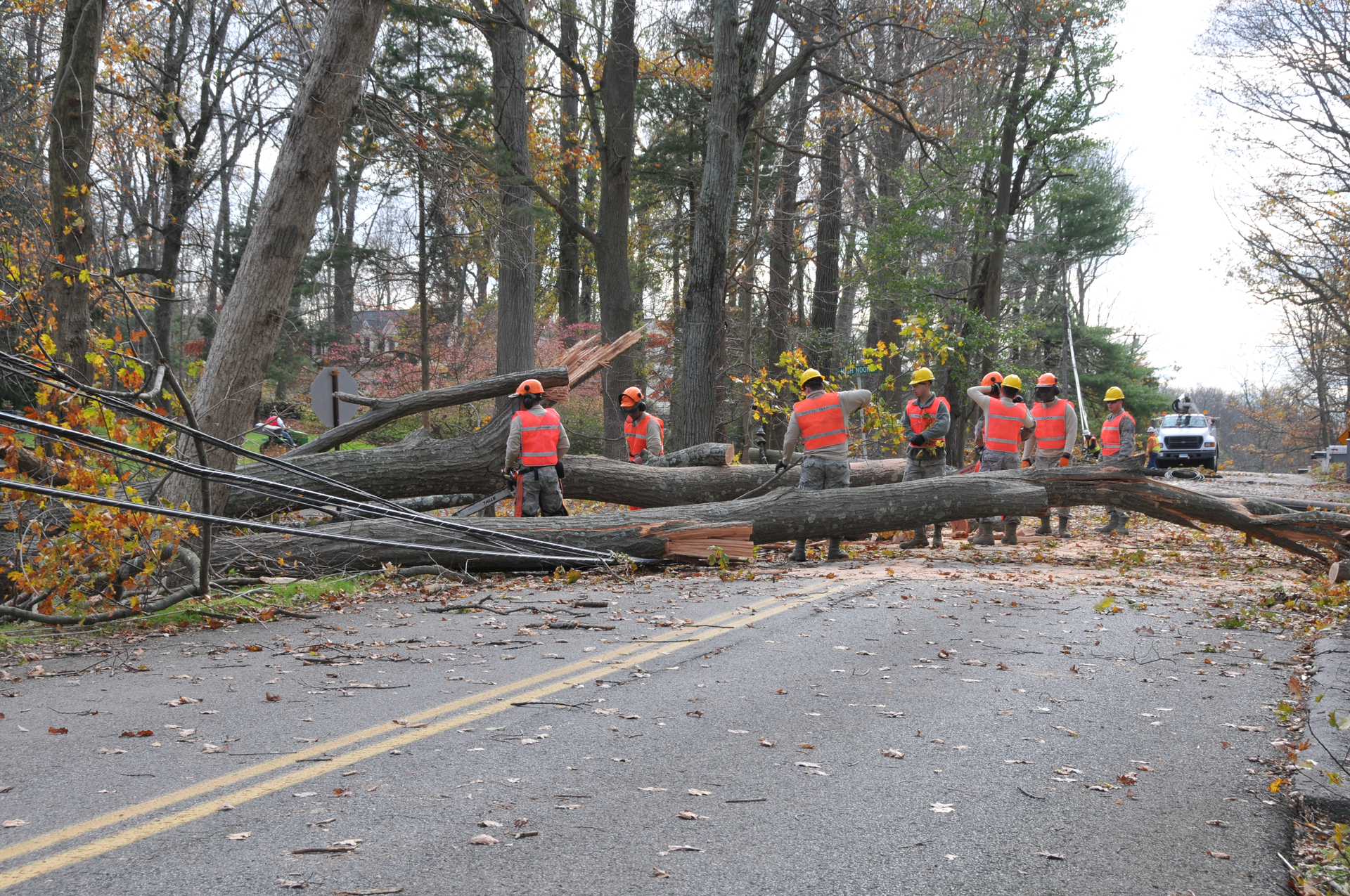 The 103rd Civil Engineer Squadron chainsaw team cut up a fallen tree to clear the road and facilitate power restoration in a Southern Connecticut town in 2012
