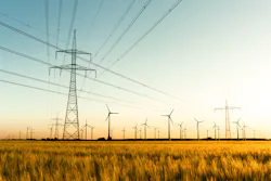 Corn field with power poles and wind turbines. Photo taken in autumn sunlight shortly before sunset. Corn field with power poles and wind turbines. Photo taken in autumn sunlight shortly before sunset.
