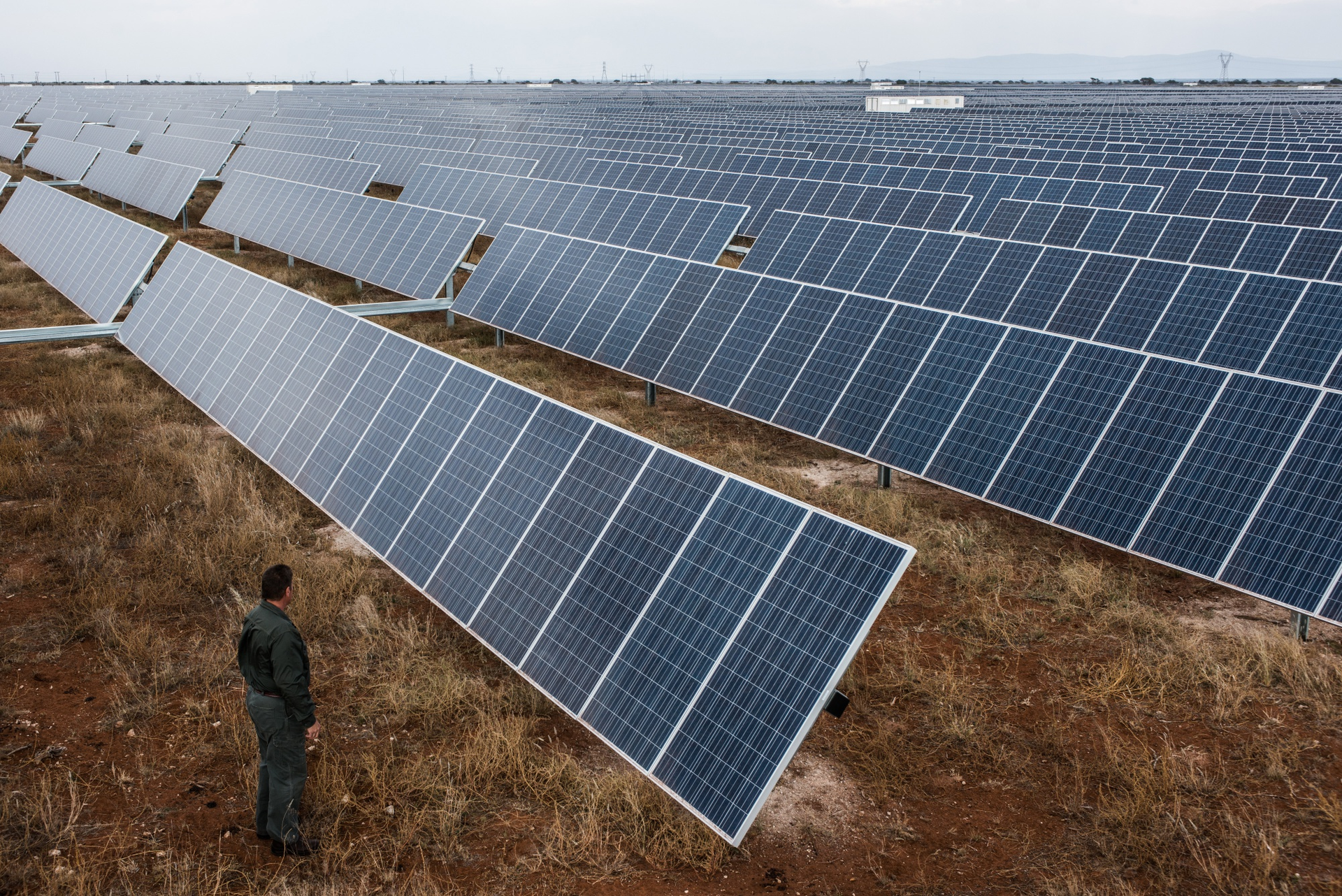 A visitor inspects photovoltaic panels at Sishen solar park in Kathu, Northern Cape, South Africa