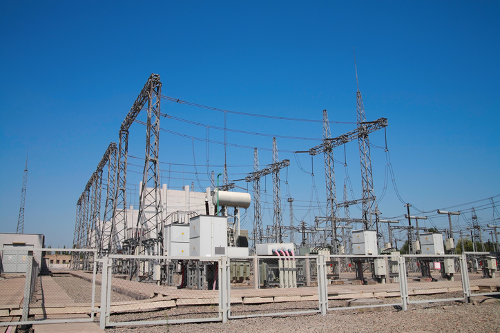 A fenced high-voltage station against the blue sky