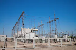 A fenced high-voltage station against the blue sky A fenced high-voltage station against the blue sky