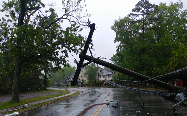 A damaged pole with hanging power lines