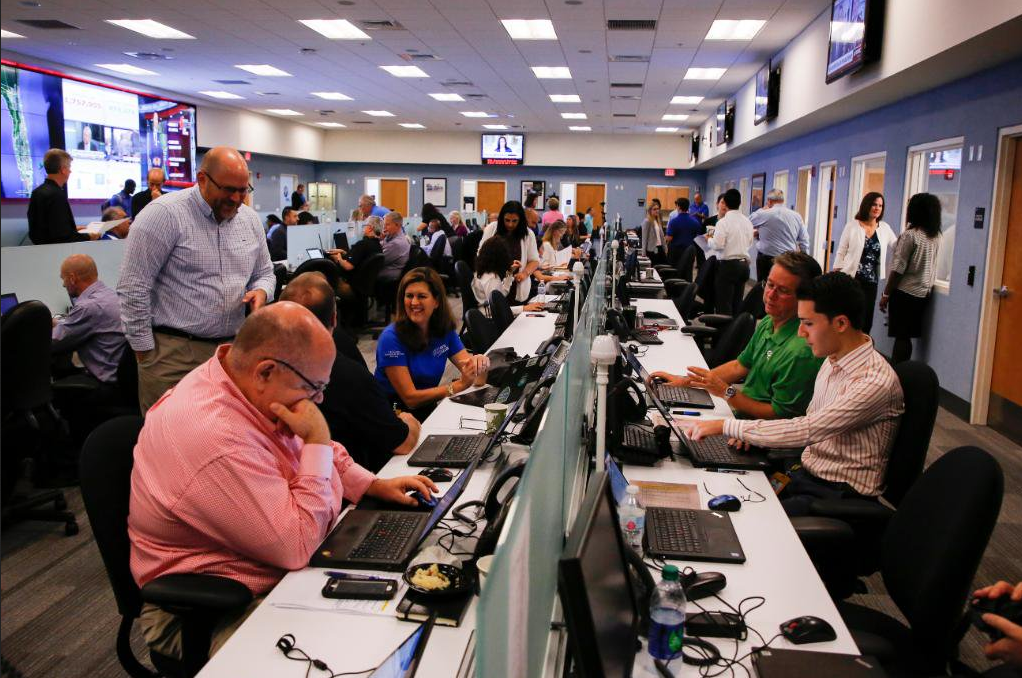A room full of people working on computers and laptops