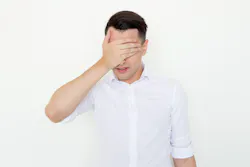 A man covering his eyes with his hand A man covering his eyes with his hand