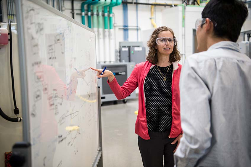 NREL researchers discussing data on a whiteboard