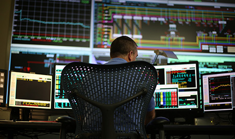 A man working with data on multiple computers