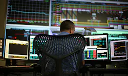 A man working with data on multiple computers A man working with data on multiple computers