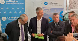 A group of people standing in front of Auvergne Rhône-Alpes banners A group of people standing in front of Auvergne Rhône-Alpes banners