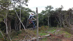 Lineman Mike Teter climbs the first of 94 poles that would be used to reach Villa Cotoca in Bolivia. Lineman Mike Teter climbs the first of 94 poles that would be used to reach Villa Cotoca in Bolivia.