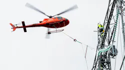 Statnett line worker installs 420-kV insulators aided by helicopter. Statnett line worker installs 420-kV insulators aided by helicopter.