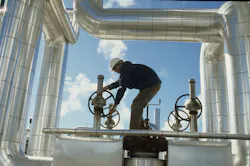 A worker adjusts valves at a California solar thermal power plant. A worker adjusts valves at a California solar thermal power plant.