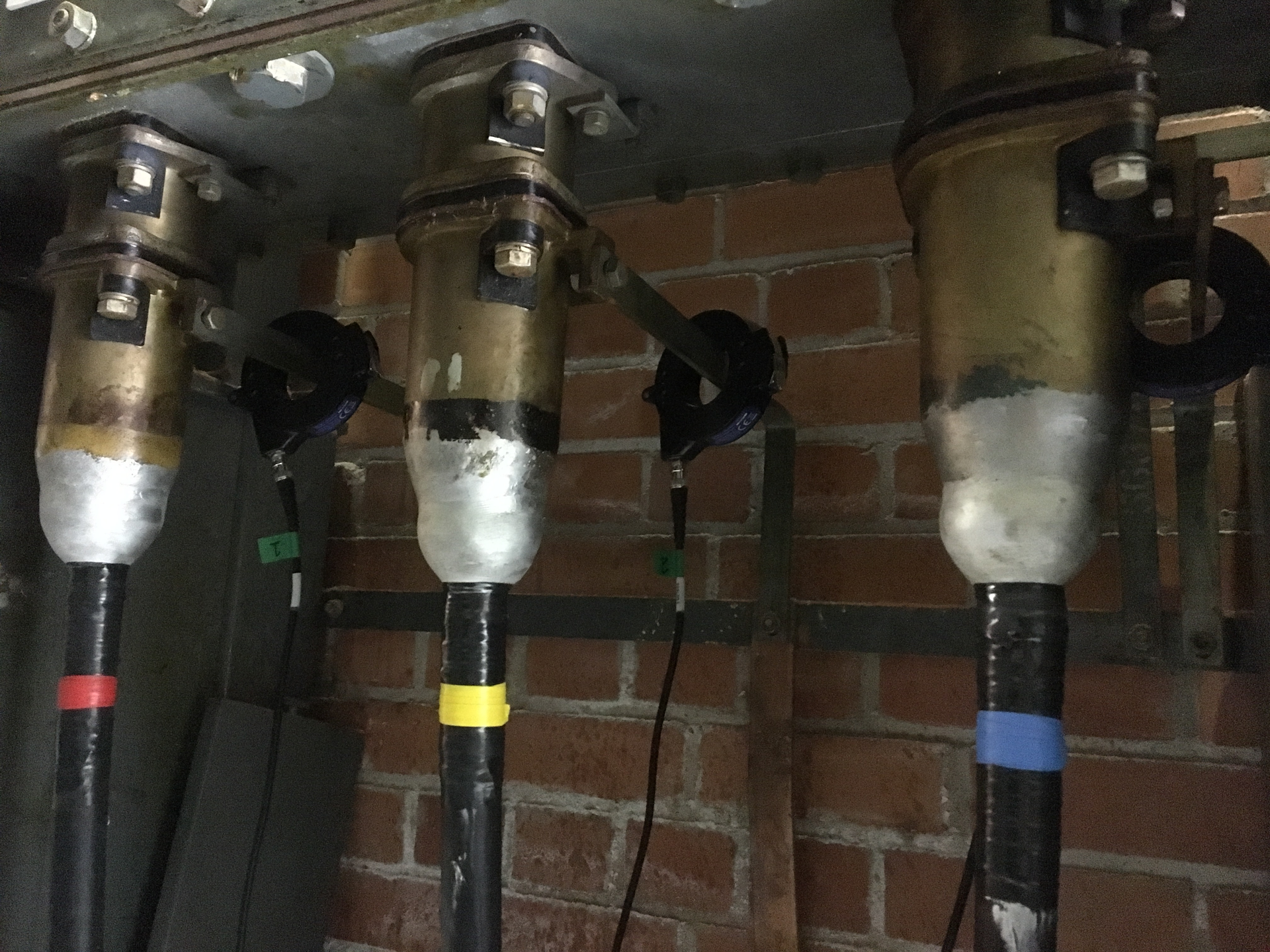 High Frequency Current Transformer (HFCT) Sensors clipped around the cable earth straps.