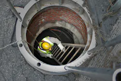 Underground worker enters underground electric vault. Underground worker enters underground electric vault.
