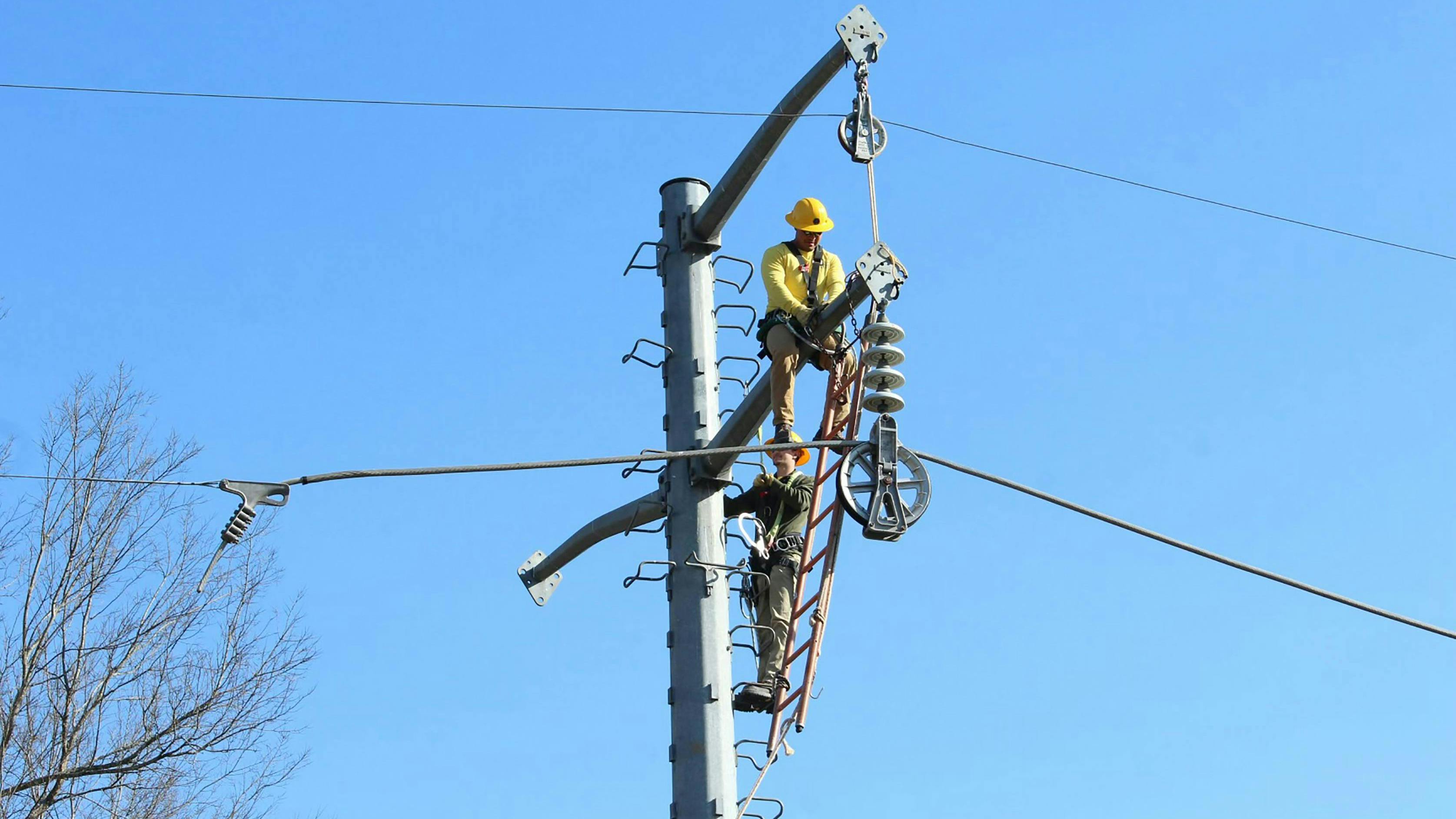 Linemen installing conductor.
