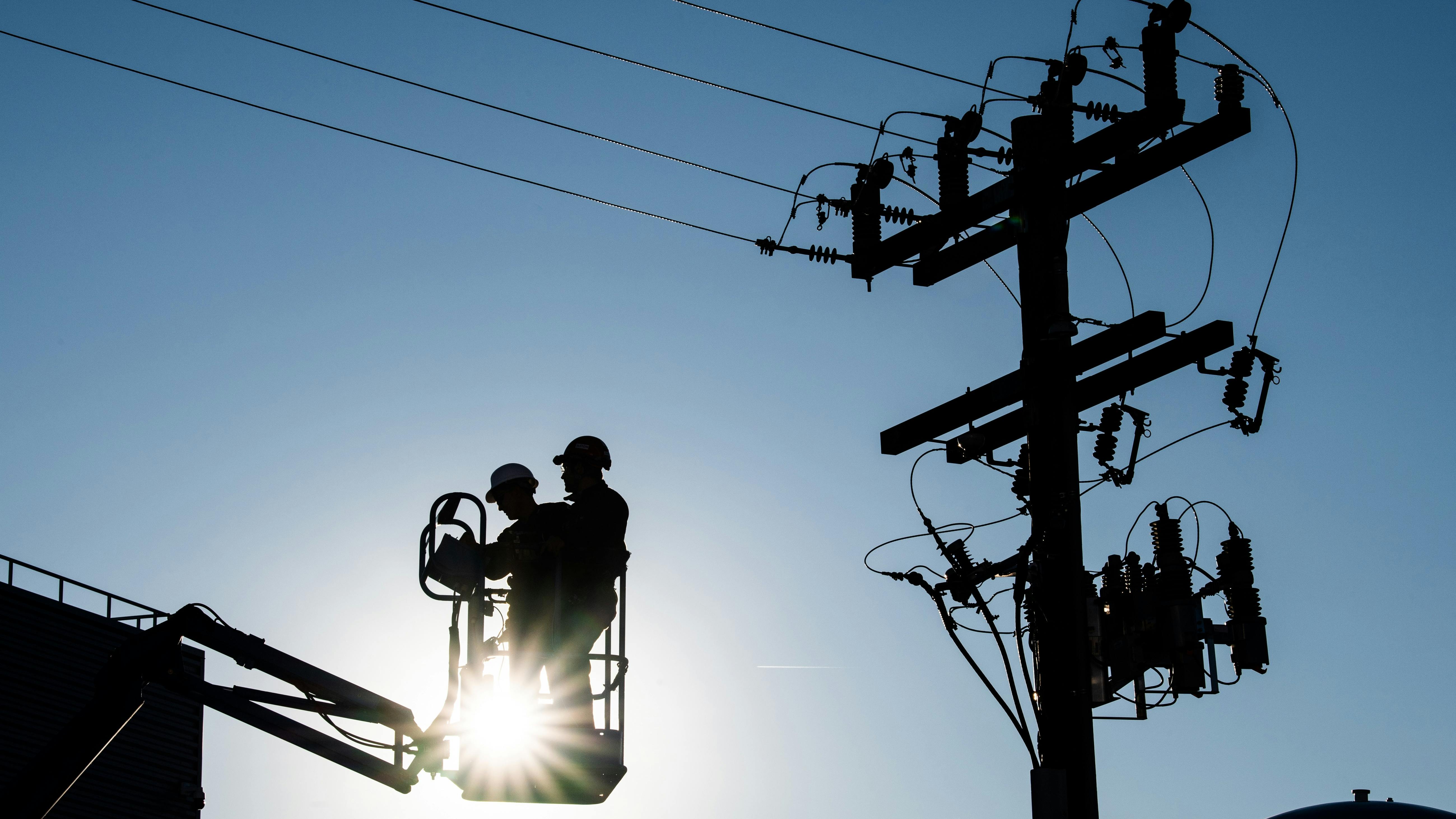 lineworkers in front of light