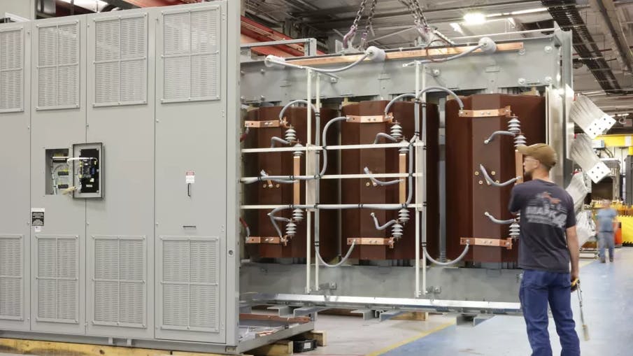 Large transformers are assembled at a Hitachi Energy plant.