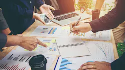 Colleagues meeting for strategy planning with data graphs and other documents. Colleagues meeting for strategy planning with data graphs and other documents.