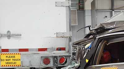 A Chevrolet Malibu is crashed into the rear of a Strick van trailer as part of the Insurance Institute for Highway Safety research program on underride guards This crash involved striking only the outer edge of the crossbar Guards proved effective in preventing underride as long as the automobile struck at least one of the vertical supports