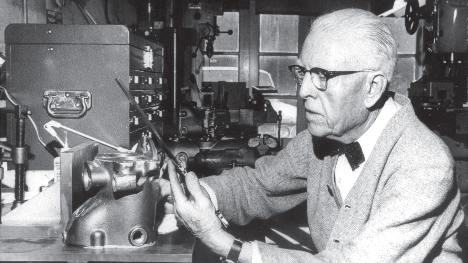 Clessie Cummins in his workshop working on an engine compression brake.