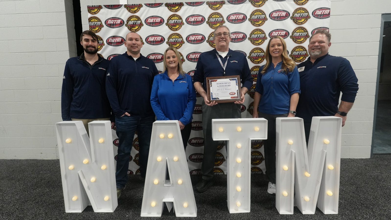 Optronics International President and CEO Brett Johnson proudly displays one of three Trailer Trends & Tech Showcase awards the company took home from the NATM convention this year.