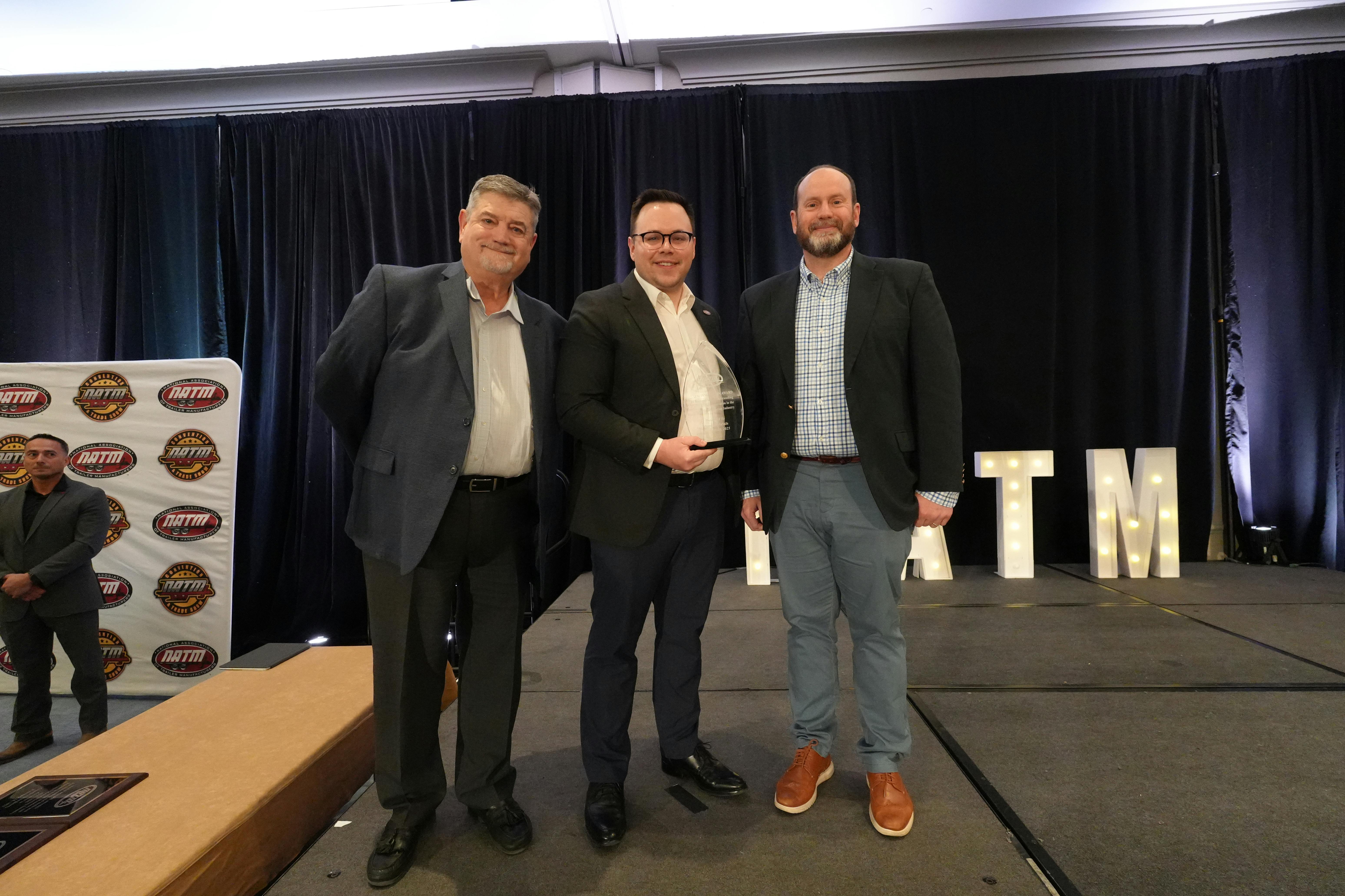 NATM Executive Director Alex Stowe, center, presents the Innovation Award to Shapiro Metals President & Chief Operations Officer Bob Alvarez, left, and Bo Howard, VP of business development.