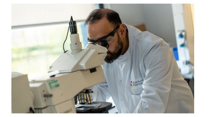 Figure 1. A scientist inspecting quantum dot films using an optical microscope.