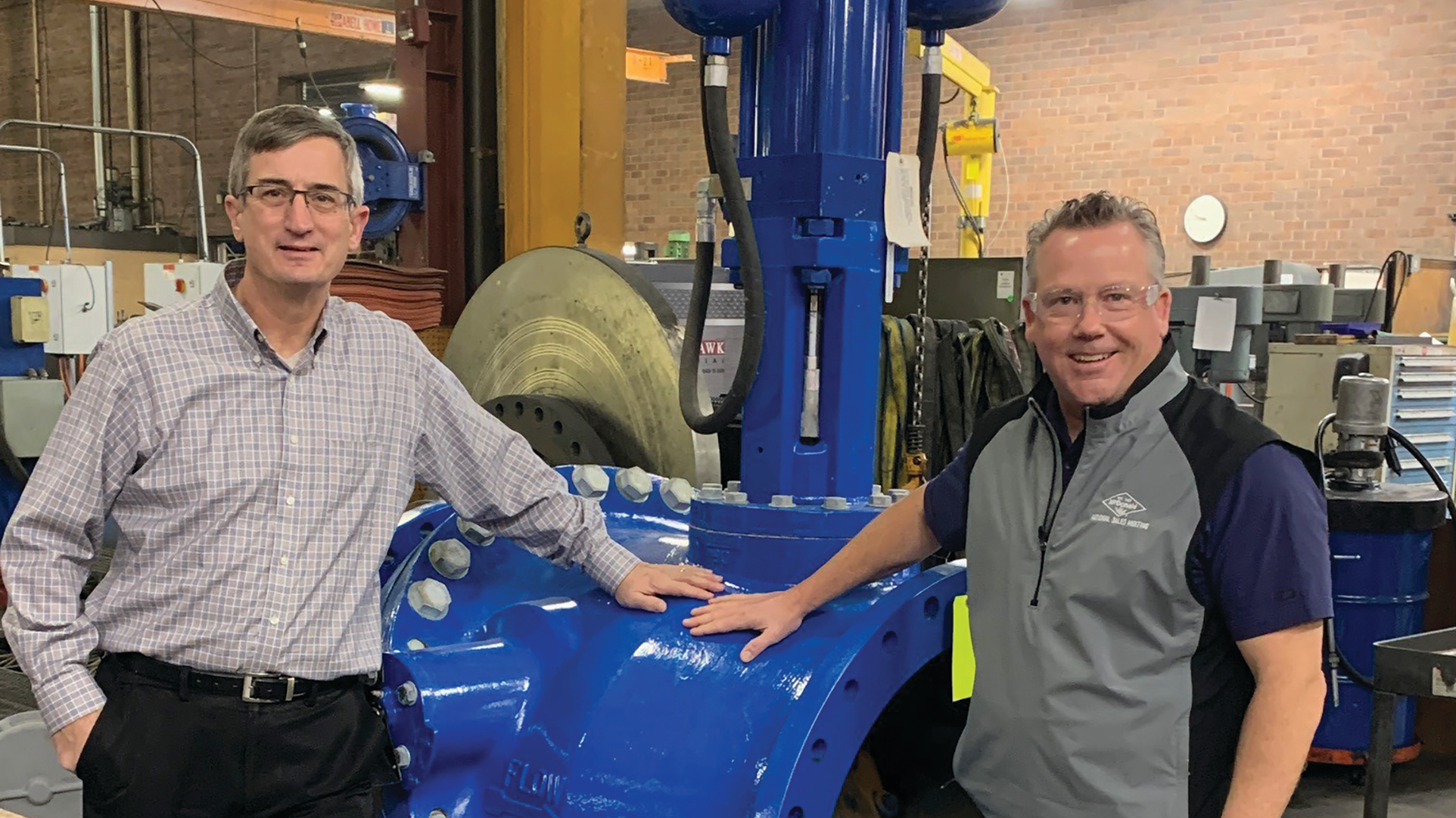 John Ballun and Rob McDonald standing next to a 30' Tilted Disc Check Valve at Val-Matic&rsquo;s Elmhurst facility.