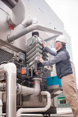 A facility manager checks the Smart Shield water treatment system for a cooling tower. A facility manager checks the Smart Shield water treatment system for a cooling tower.