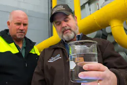 Technicians examine a clean water sample taken from an industrial cooling tower. Technicians examine a clean water sample taken from an industrial cooling tower.