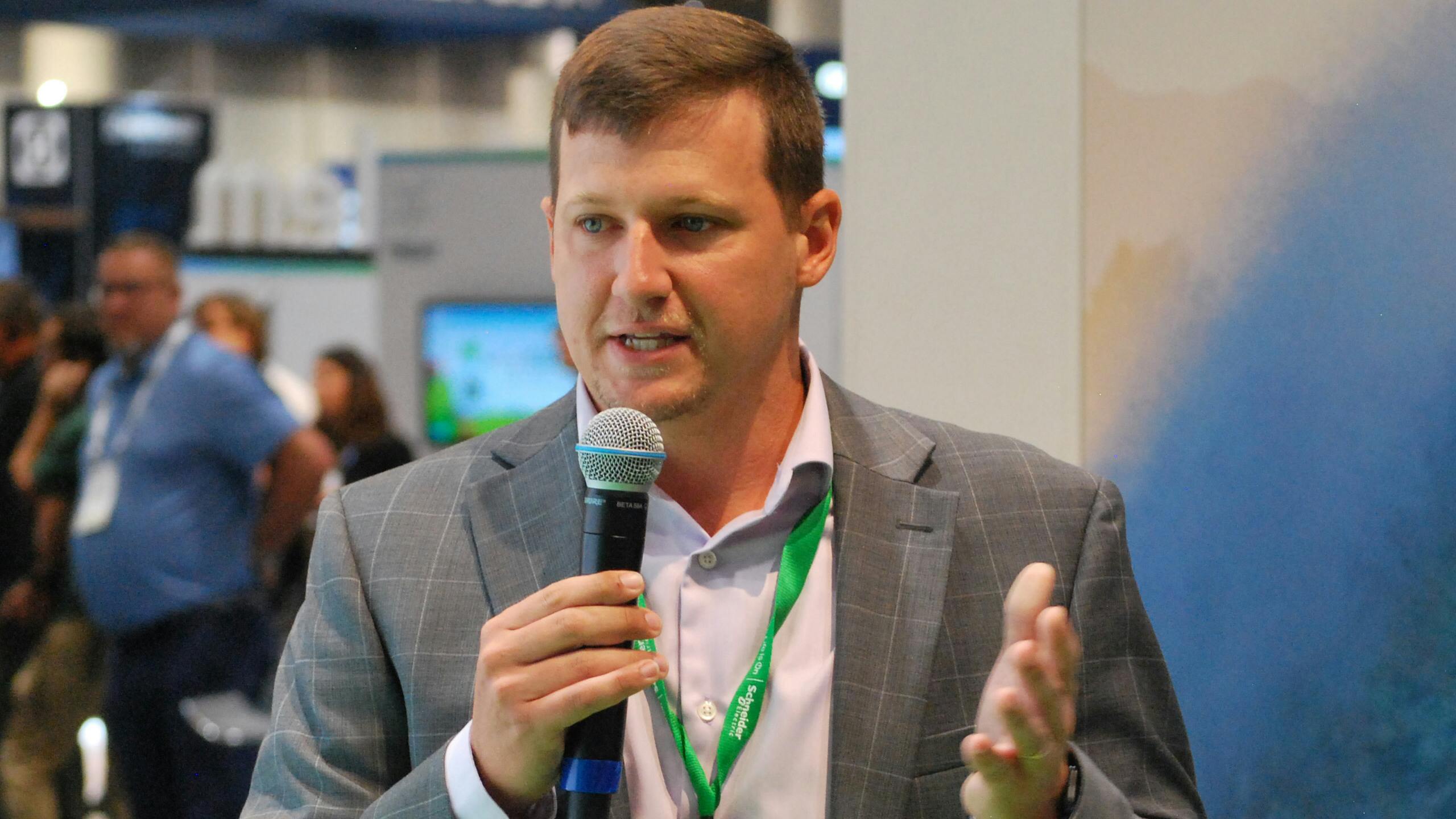 Schneider Electric water and wastewater business development leader Jacob Thompson speaks at the company's booth at WEFTEC 2024 in New Orleans.