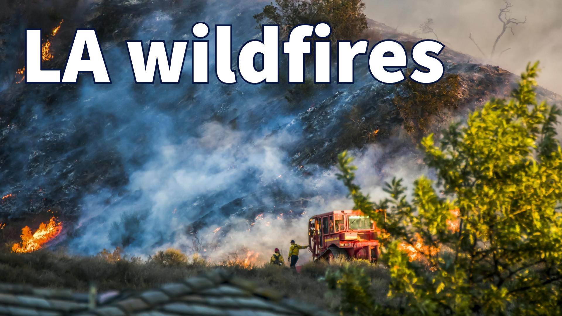 Two Firefighters Stand Next to Bulldozer with Hillside Burning in Background during California Fire.